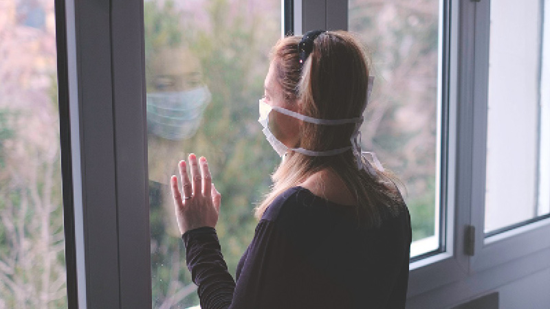 lady wearing facemask beside window